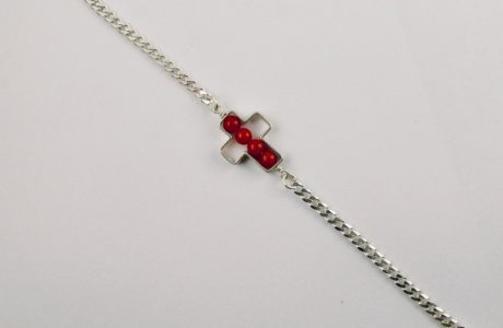 Une chaîne maille gourmette et 4 perles 4 mm de véritable corail rouge de Méditerranée, délicatement enchâssées dans une croix ajourée,  en argent 925/1000e