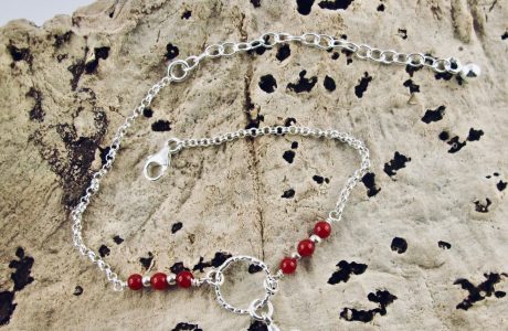 Ce bracelet est composé d'une fine chaîne en argent massif et perles 2,5mm de véritable corail rouge de Méditerranée. Un anneau en argent martelé porte le petit charms. A vous de choisir