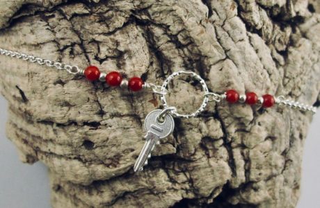 Ce bracelet est composé d'une fine chaîne en argent massif et perles 2,5mm de véritable corail rouge de Méditerranée. Un anneau en argent martelé porte le petit charms. A vous de choisir