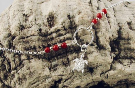 Ce bracelet est composé d'une fine chaîne en argent massif et perles 2,5mm de véritable corail rouge de Méditerranée. Un anneau en argent martelé porte le petit charms. A vous de choisir