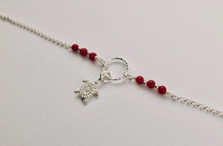 Ce bracelet est composé d'une fine chaîne en argent massif et perles 2,5mm de véritable corail rouge de Méditerranée. Un anneau en argent martelé porte le petit charms. A vous de choisir