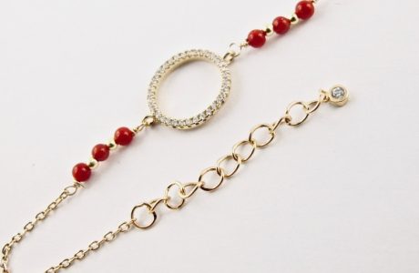 Ce bracelet est composé d'une fine chaîne en argent plaqué or et perles 2,5mm de véritable corail rouge de Méditerranée, reliée à un anneau (ø 13mm) serti de cristaux de swarovski.