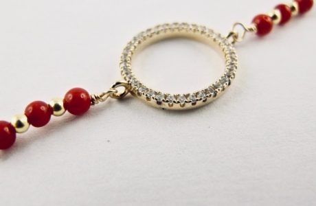 Ce bracelet est composé d'une fine chaîne en argent plaqué or et perles 2,5mm de véritable corail rouge de Méditerranée, reliée à un anneau (ø 13mm) serti de cristaux de swarovski.