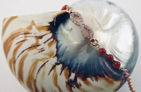Ce bracelet est composé d'une fine chaîne en argent plaqué or rose et perles 2,5mm de véritable corail rouge de Méditerranée, reliée à un infini serti de cristaux de swarovski.