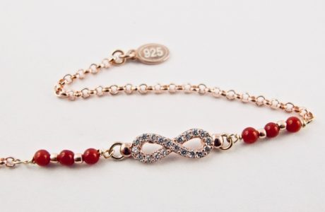 Ce bracelet est composé d'une fine chaîne en argent plaqué or rose et perles 2,5mm de véritable corail rouge de Méditerranée, reliée à un infini serti de cristaux de swarovski.