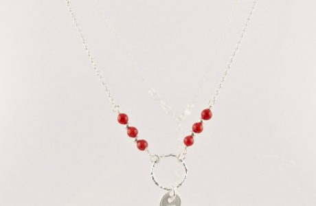 Ce collier est composé d'une fine chaîne en argent massif et perles 2,5mm de véritable corail rouge de Méditerranée. Un anneau en argent martelé porte le petit charms.