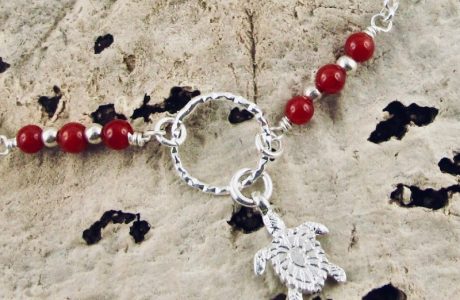 Ce collier est composé d'une fine chaîne en argent massif et perles 2,5mm de véritable corail rouge de Méditerranée. Un anneau en argent martelé porte le petit charms.