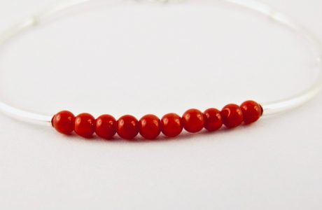 Bracelet composé d'une constellation de 10 perles de 3 mm  de véritable corail rouge de Méditerranée,et de tubes jonc de 2 cm en argent 925