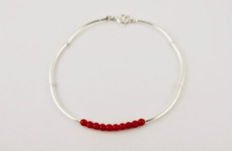 Bracelet composé d'une constellation de 10 perles de 3 mm  de véritable corail rouge de Méditerranée,et de tubes jonc de 2 cm en argent 925